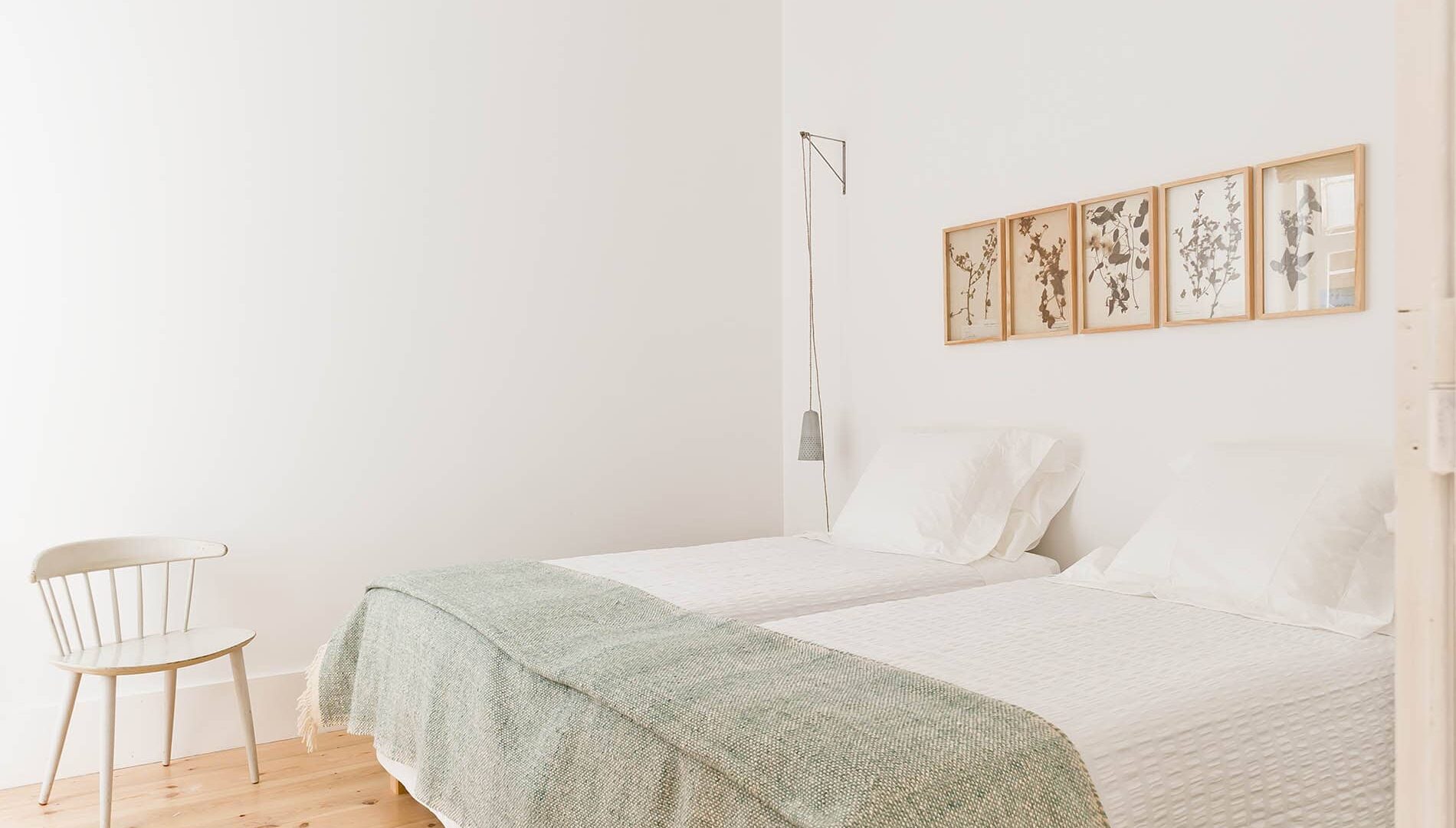 Doppelbett und Stuhl im Zimmer im Baixa House