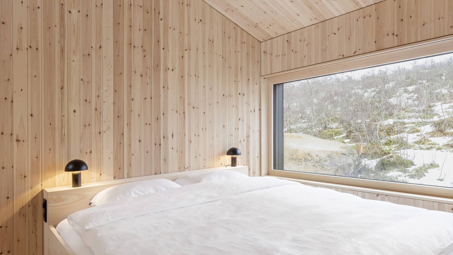 Doppelbett in Schlafzimmer mit Holzpaneelen