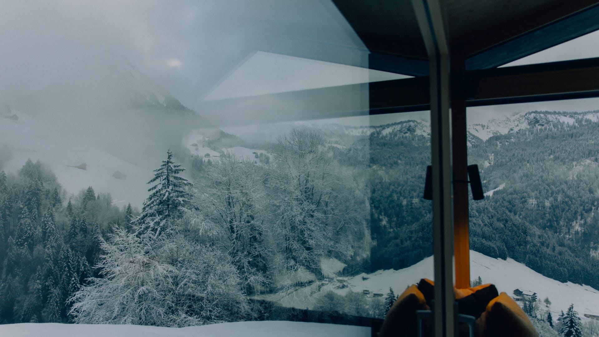 Blick aus dem Fenster auf schneebedeckte Landschaft
