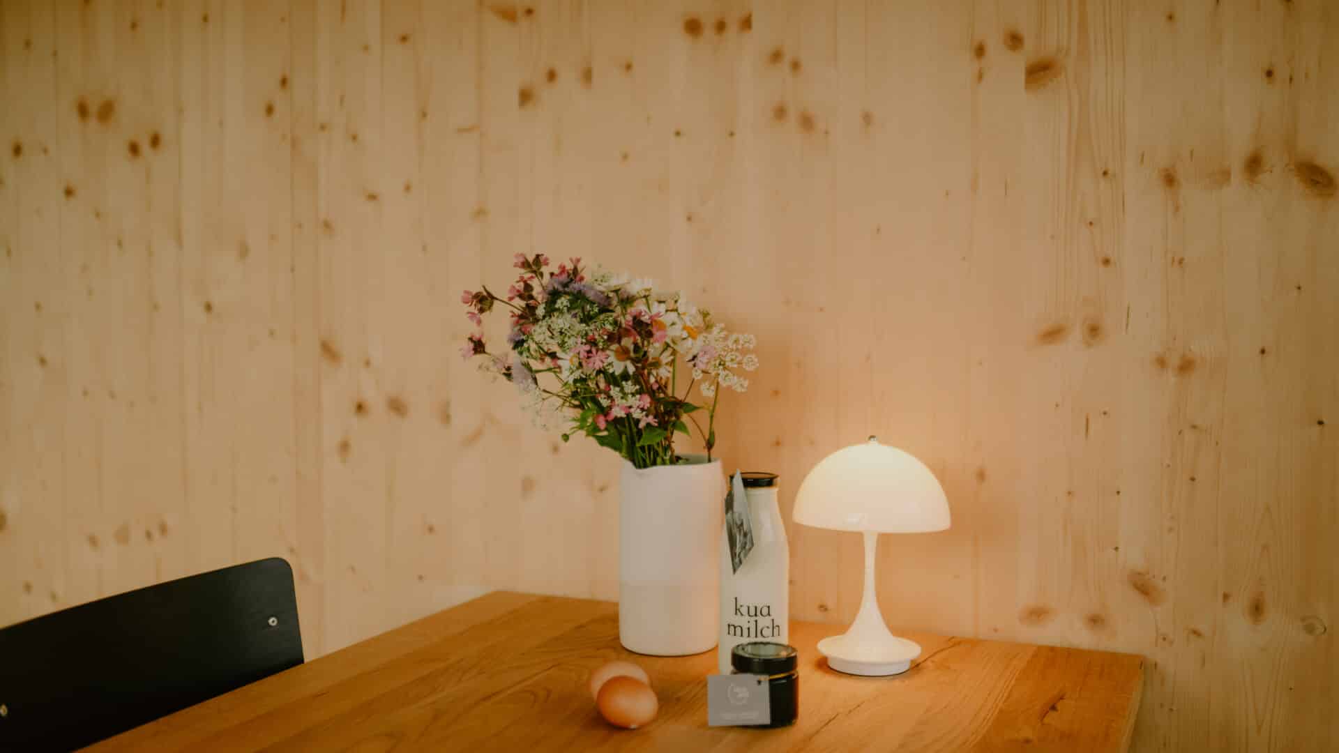 Detail: Blumen und Leuchte auf dem Esstisch