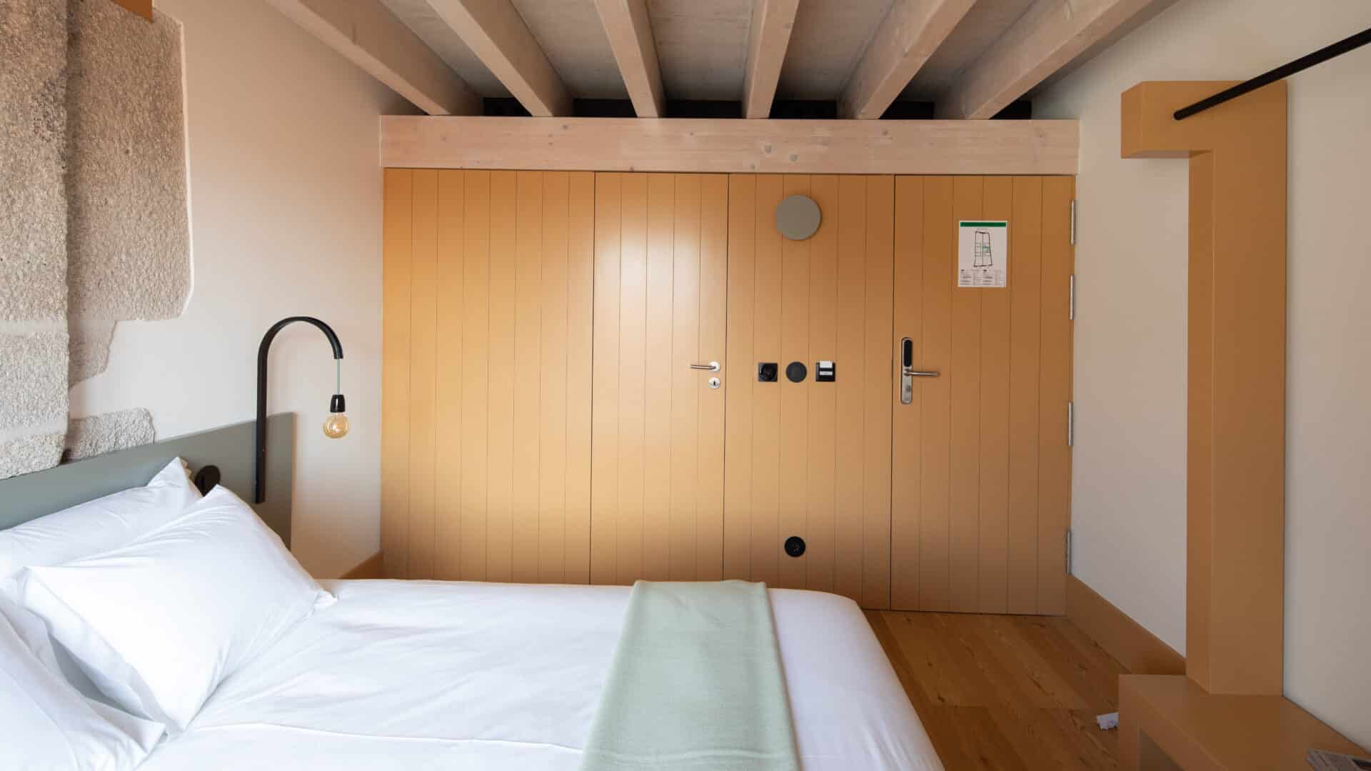 Doppelbett mit Einbauschrank im Hotel Na Travessa Suites