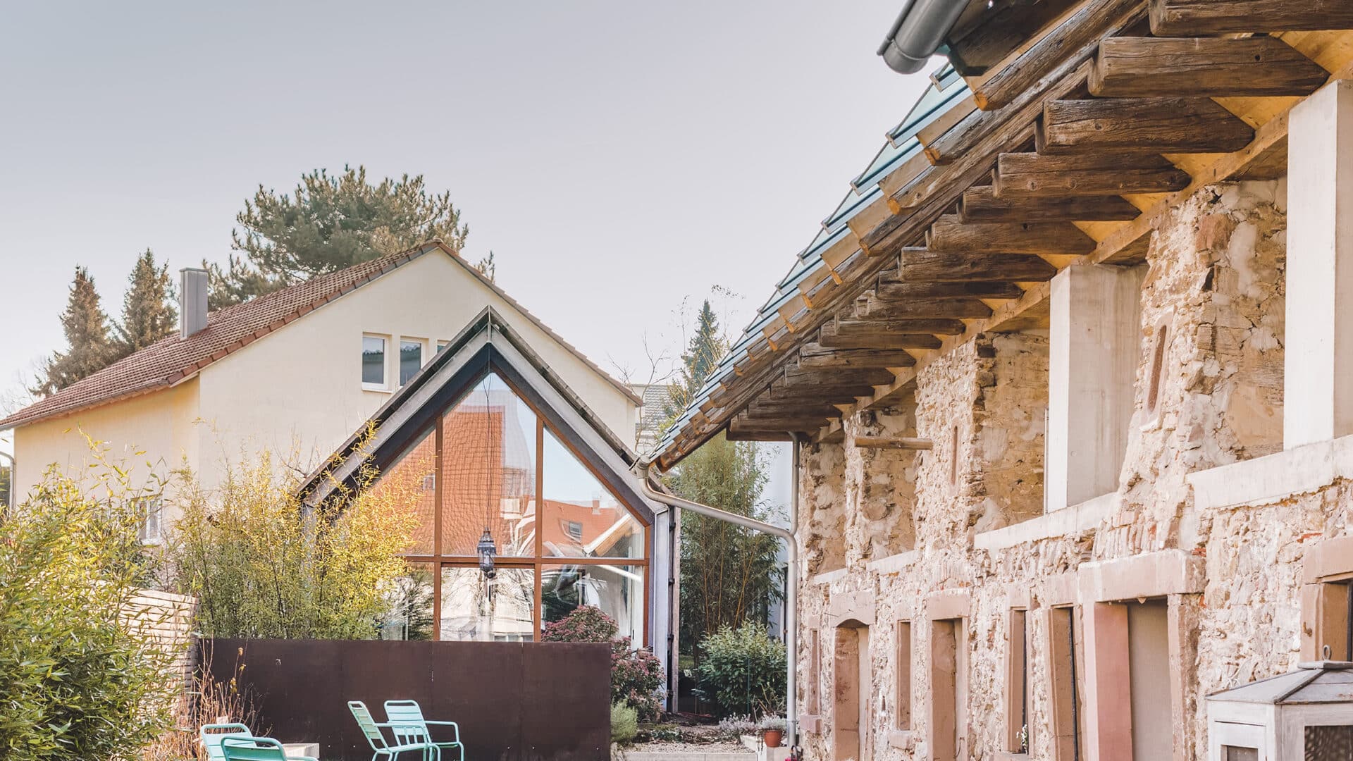 Garten mit Sitzplätzen und unverputzte Fassade des Friz BnB