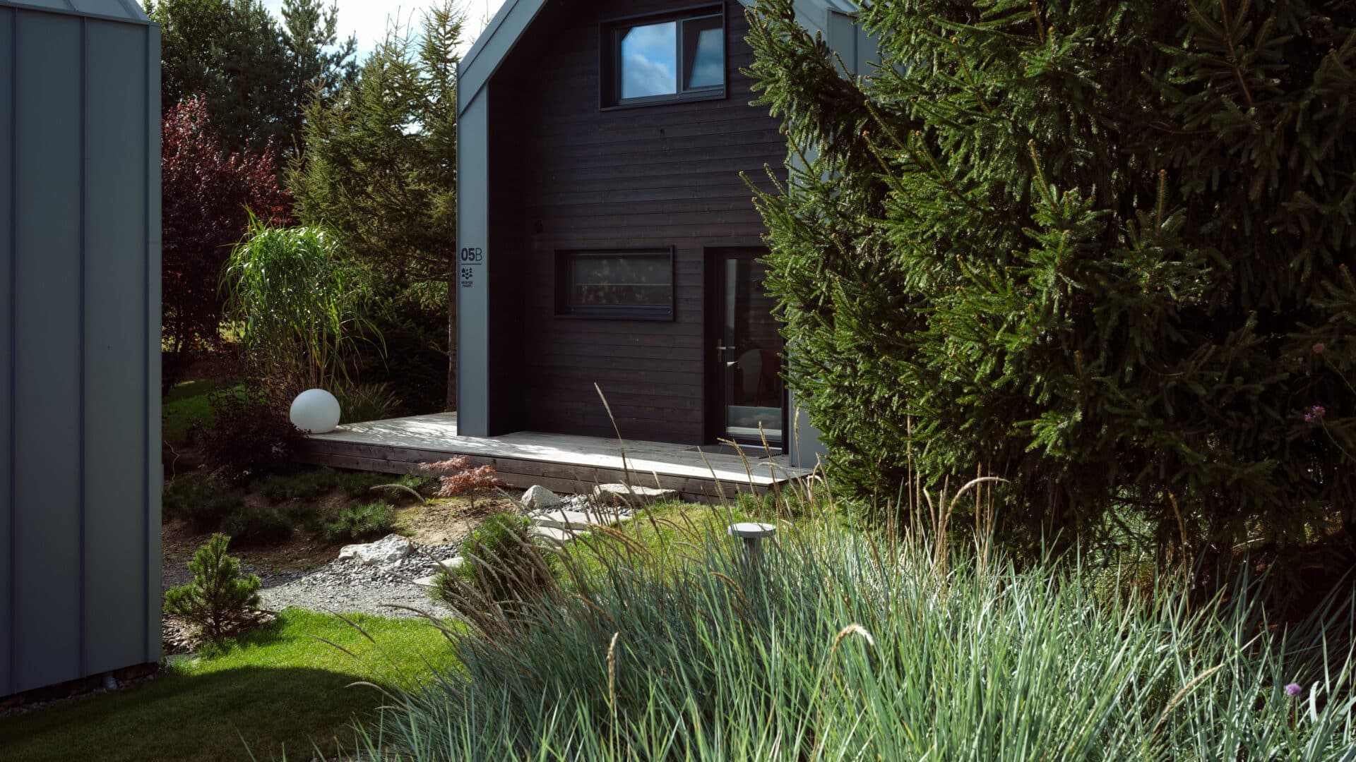Fassade aus schwarzem Holz im Garten mit Dünengras