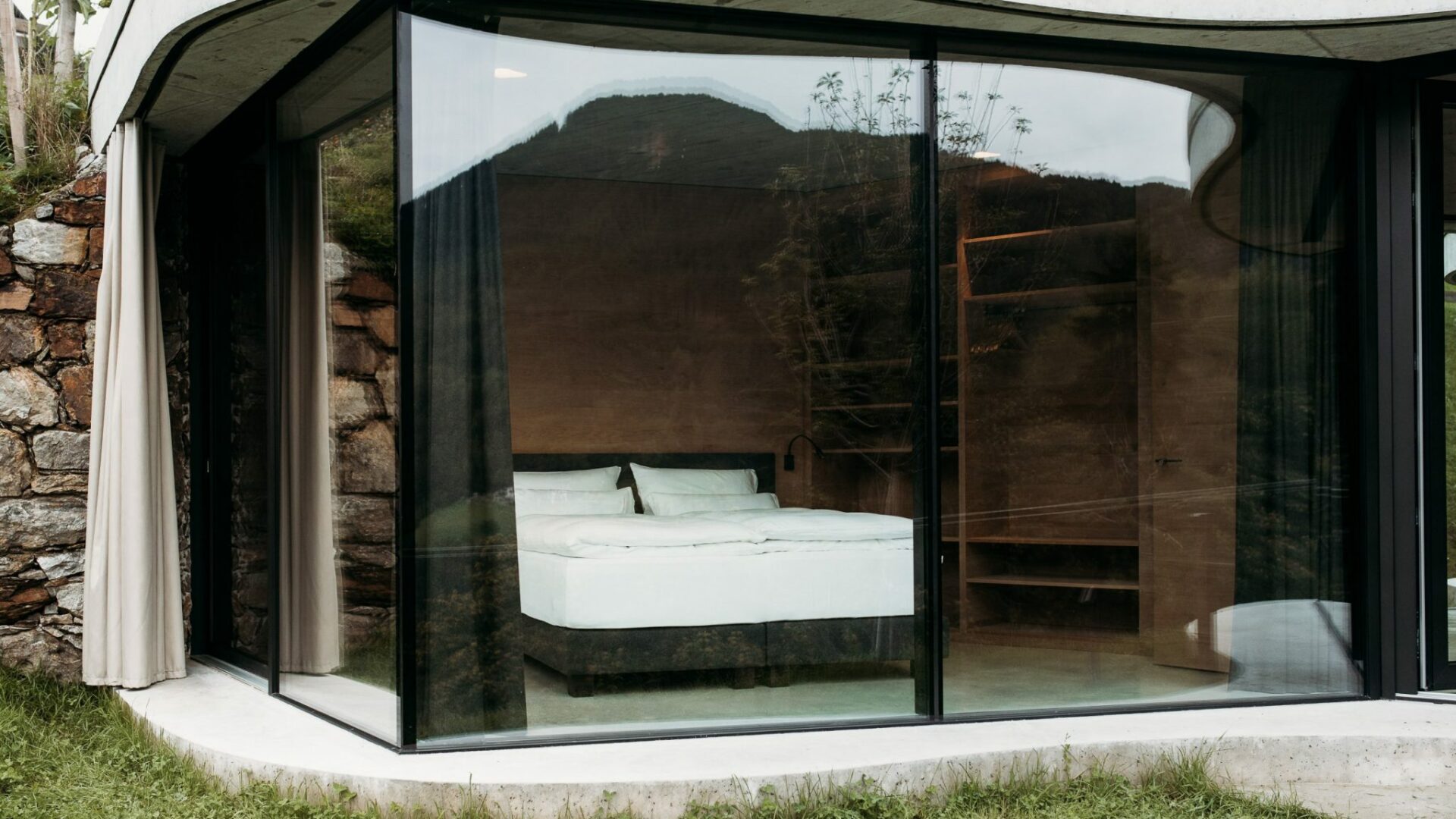 Blick von außen ins Schlafzimmer mit Bett im Gästehaus Freiform