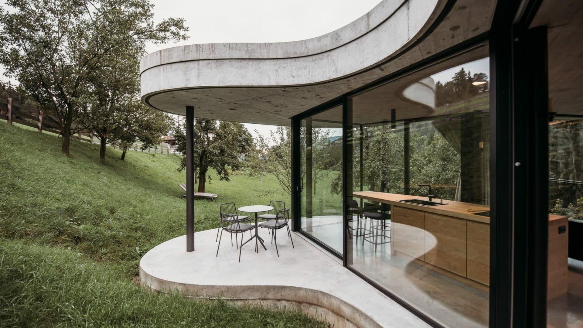 Terrasse und Küche durch große Glasfenster verbunden im Gästehaus Freiform