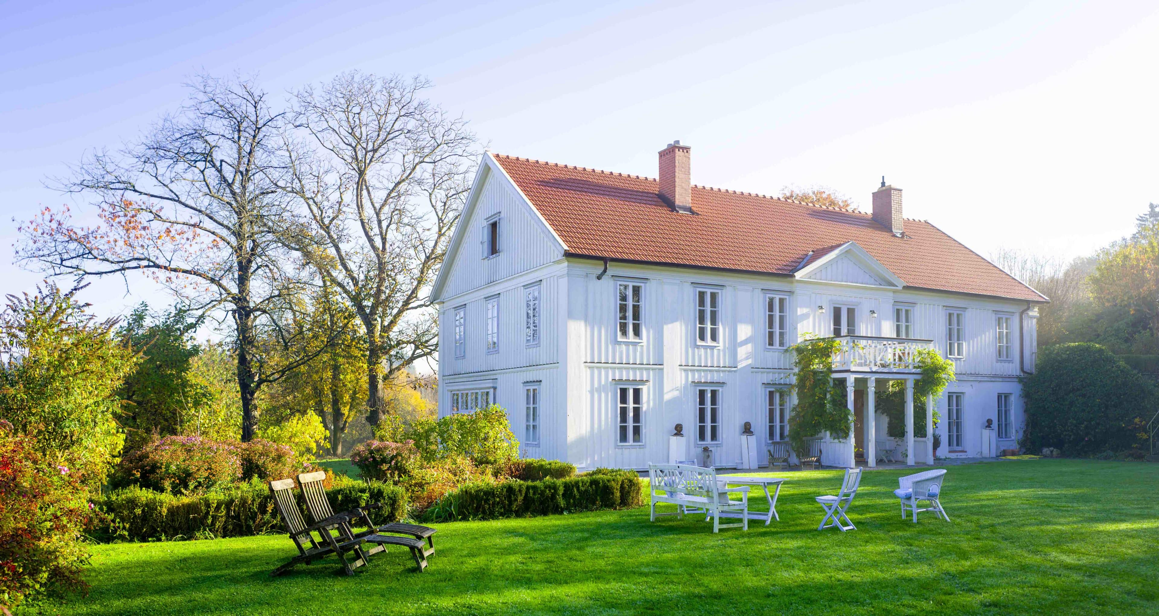 das weiße Haupthaus mit Sitzplätzen im Garten auf Hof Grillenöd
