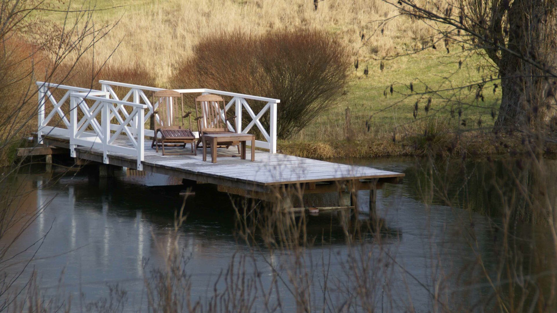 Steg mit Holzstühlen am See