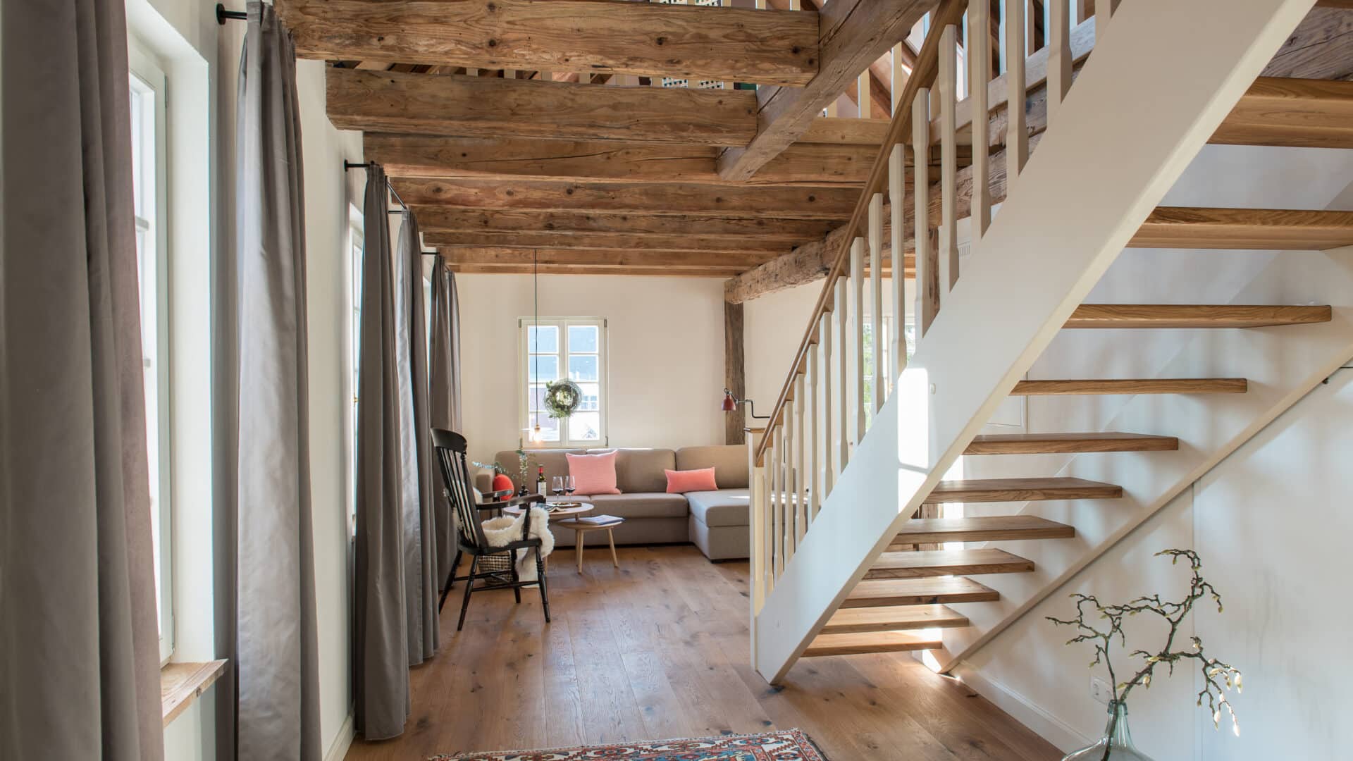 Wohnzimmer mit Sofa und Treppe im Palais Wunderlich