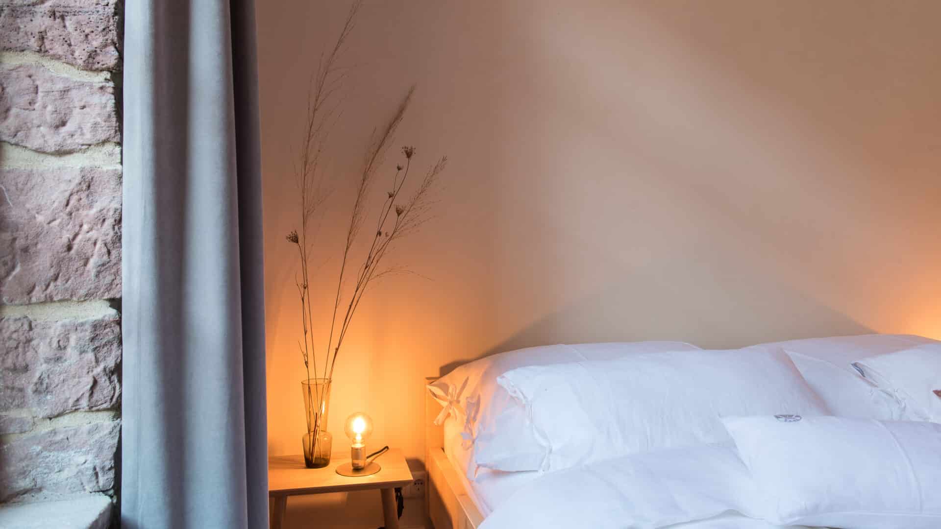 Bett und Nachttisch im Zimmer im Palais Wunderlich