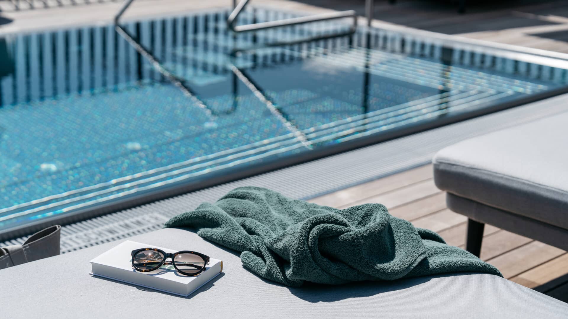 Handtuch, Brille und Buch am Pool im Refugium Lunz