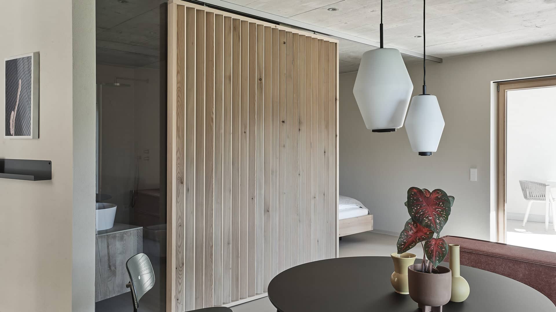 Zimmer mit Tisch und Badezimmer im Refugium Rochus