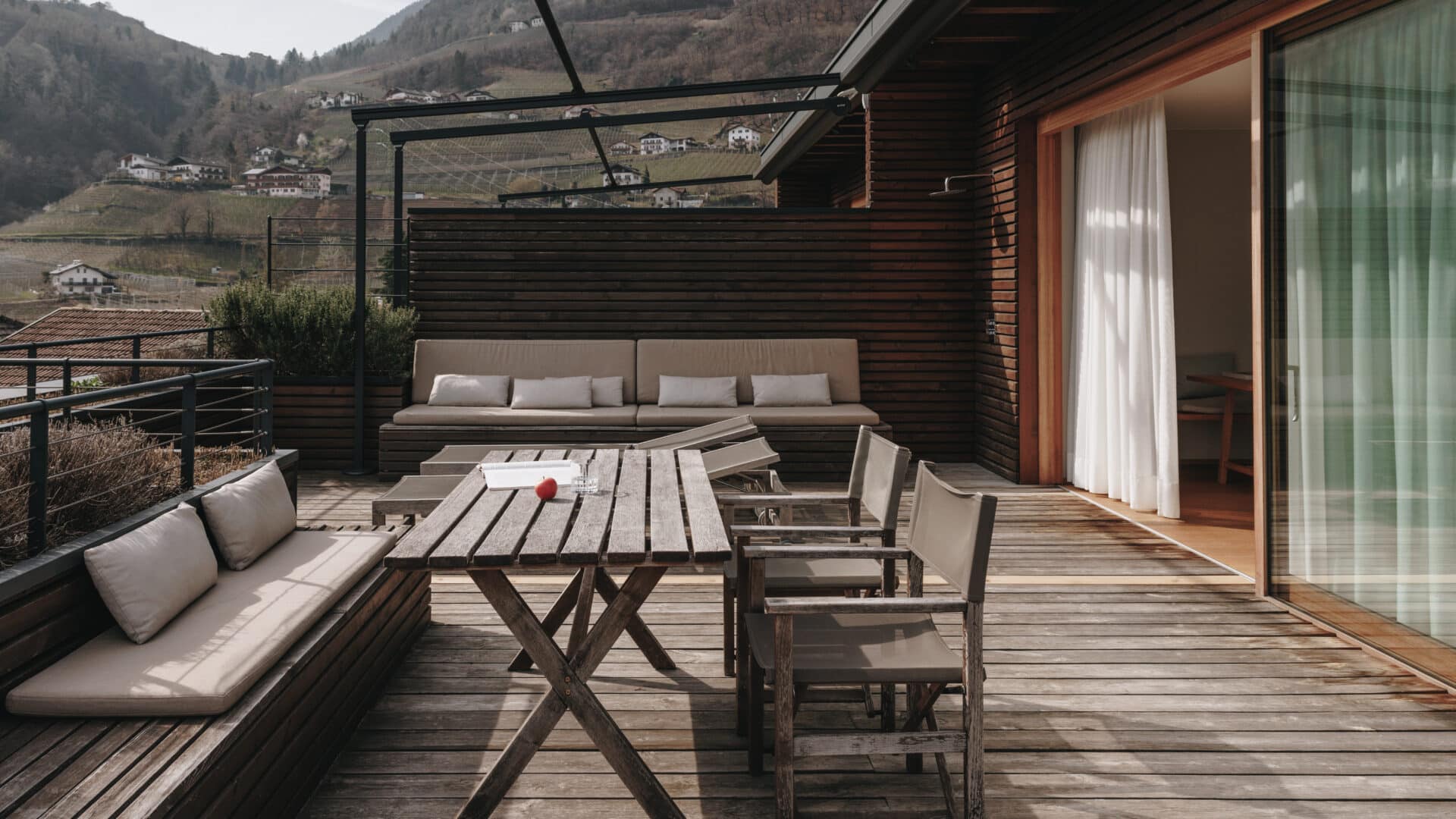 große Terrasse mit Sitzecke, Tisch und Sonnenliegen im Hotel Schwarzschmied