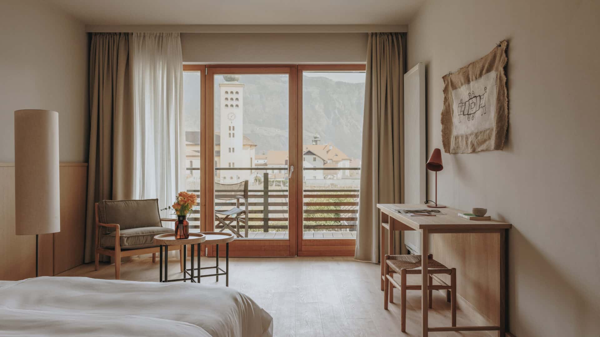 Doppelzimmer mit großer Fensterfront und Ausblick auf die Berge im Hotel Schwarzschmied