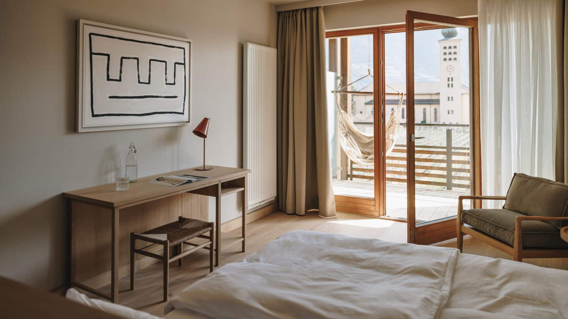 Doppelzimmer mimt Schreibtisch, Balkon und Hängesessel im Hotel Schwarzschmied