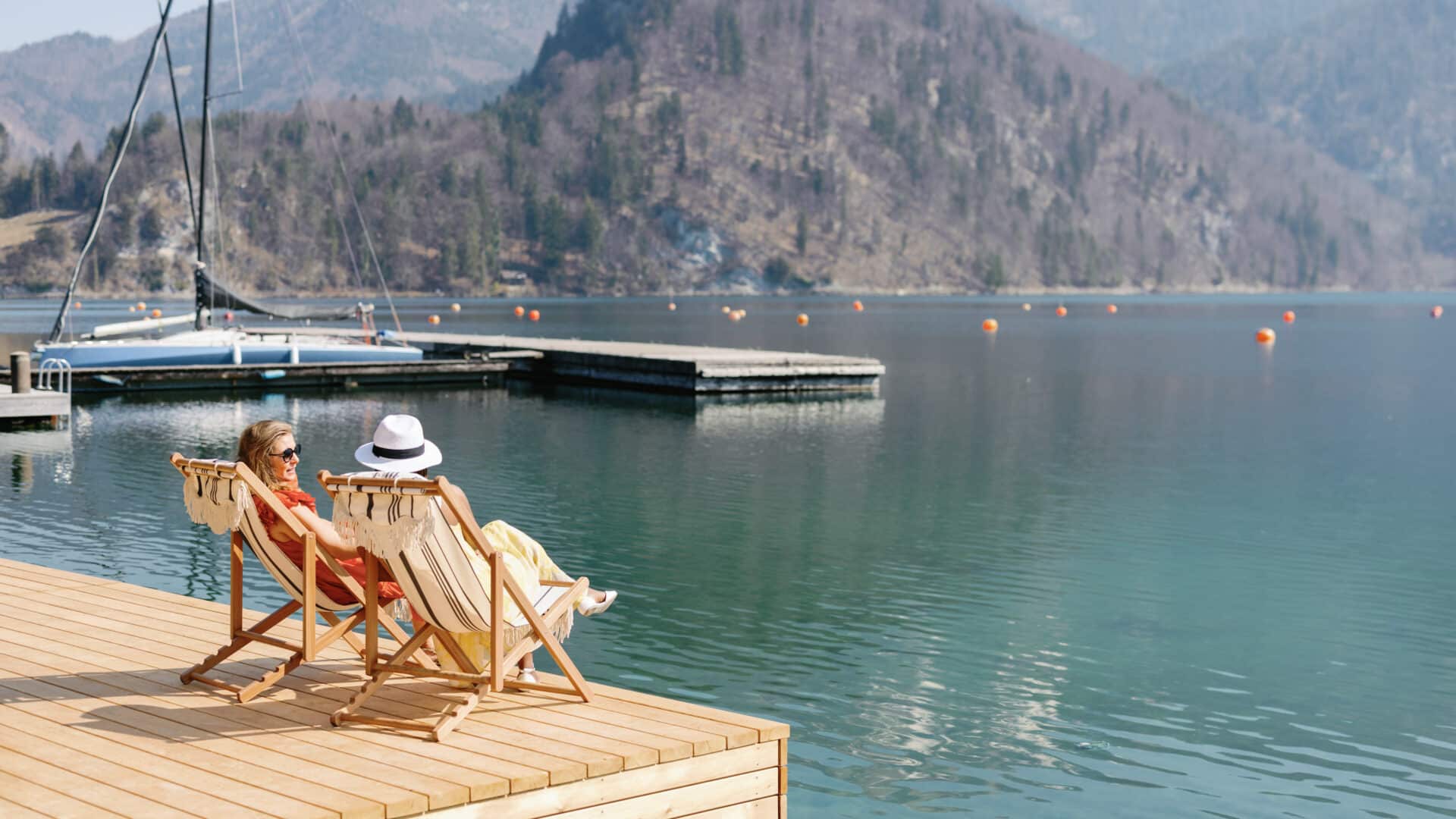 Zwei Gäste auf einem Steg am See in der Villa Alma